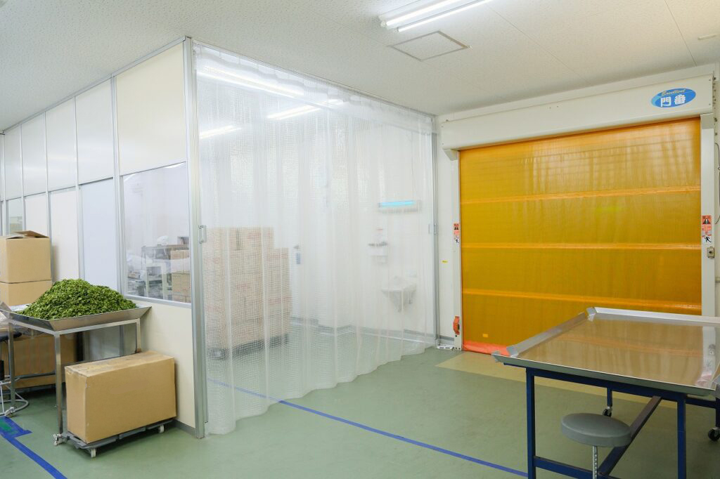 黄色い自動シャッターと透明のビニールカーテンで区切られた部屋写真